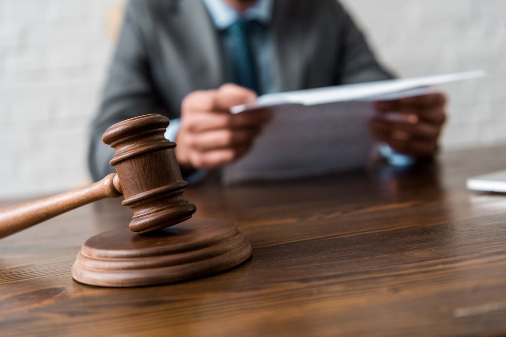 Close-up view of a wooden hammer and judge working with documents, featuring 411 Personal Injury Law and highlighting the legal aspects of product liability claims, ensuring alignment with the page's context.
